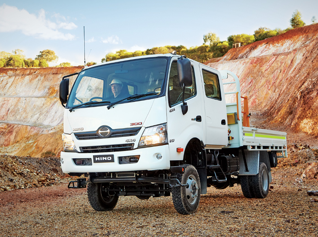 White Hino 300 four-wheel-drive crew-cab tray truck in a quarry